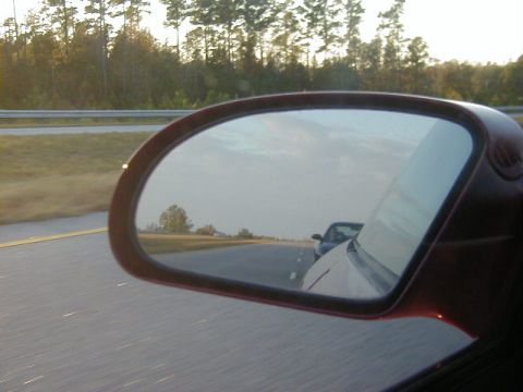 1994 Ford Probe - View of another car in the side mirror while driving on the highway.