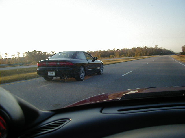 Black coupe with a license plate reading '913-417' driving on a highway