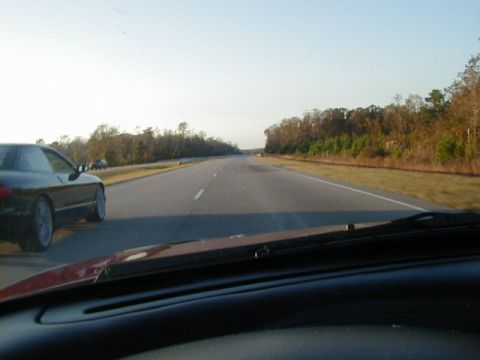 1994 Ford Probe - A black 1994 Ford Probe is seen from the perspective of another vehicle on a highway.