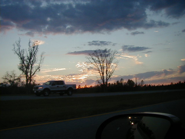 Pickup truck driving on highway at sunset, seen from another vehicle