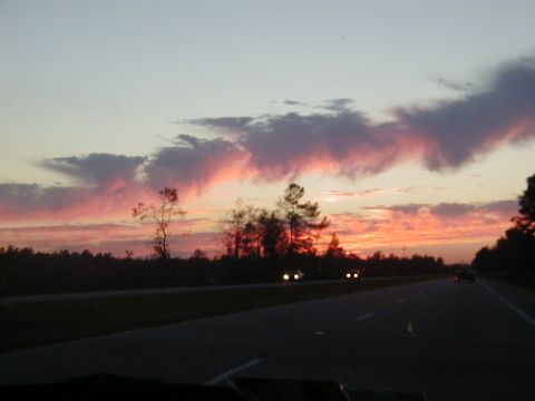 1994 Ford Probe - A scenic sunset over a highway, with two cars visible in the distance and colorful clouds painting the sky.