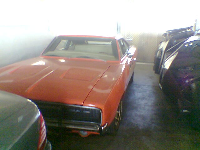 Orange 1970 Dodge Charger R/T parked next to a black car