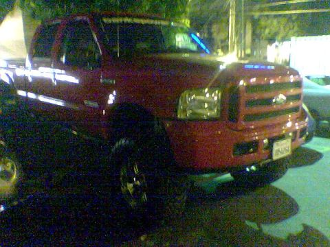 1988 Ford Bronco - Front view of a red pickup truck, possibly a Ford F-Series, parked outdoors.