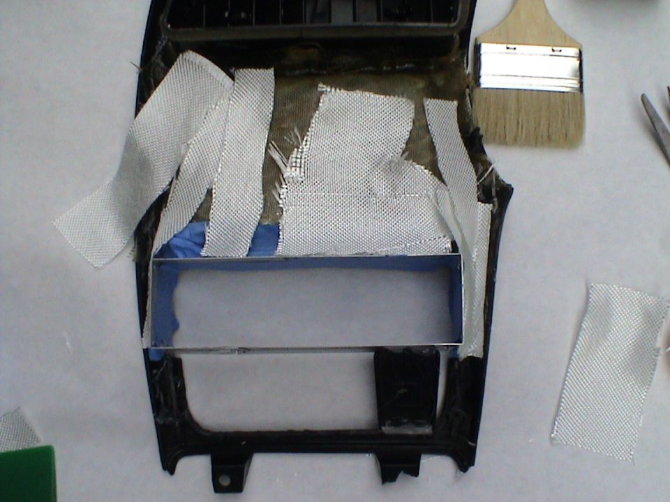 Center console trim piece with fiberglass strips and a brush nearby