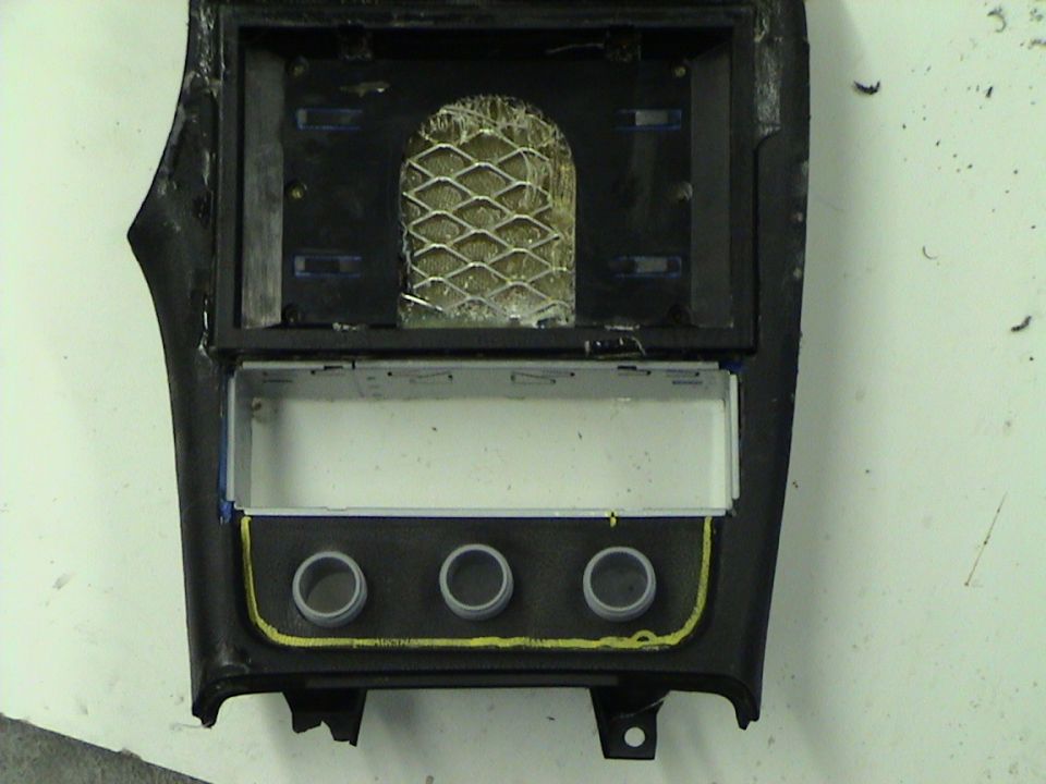 Car center console trim piece with openings for radio and three knobs