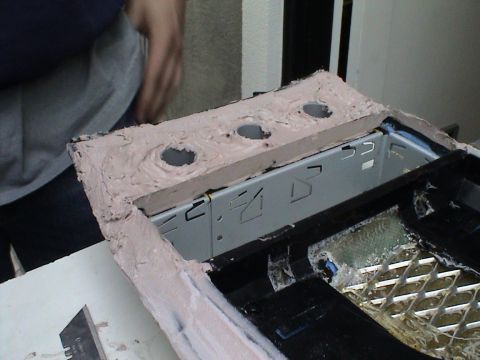 1997 Ford Probe - A custom center console is being modified with body filler and cutouts, revealing an underlying metal bracket.