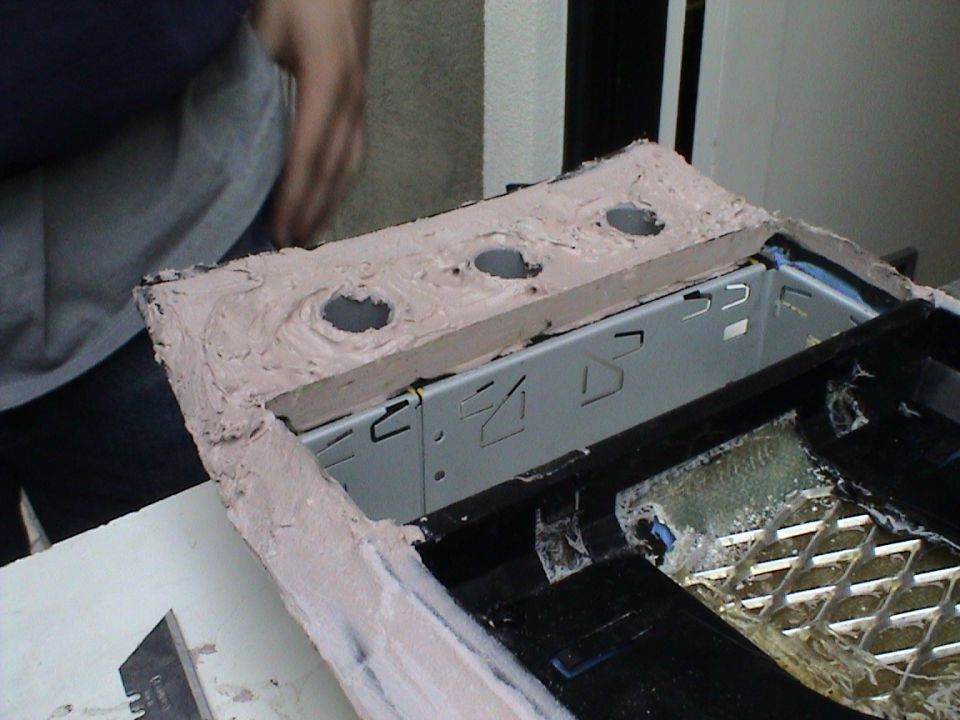 Custom center console modification with three circular cutouts and a metal bracket