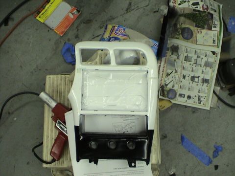 1997 Ford Probe - A car's center console part is shown with various items around it, including a heat gun and newspapers.