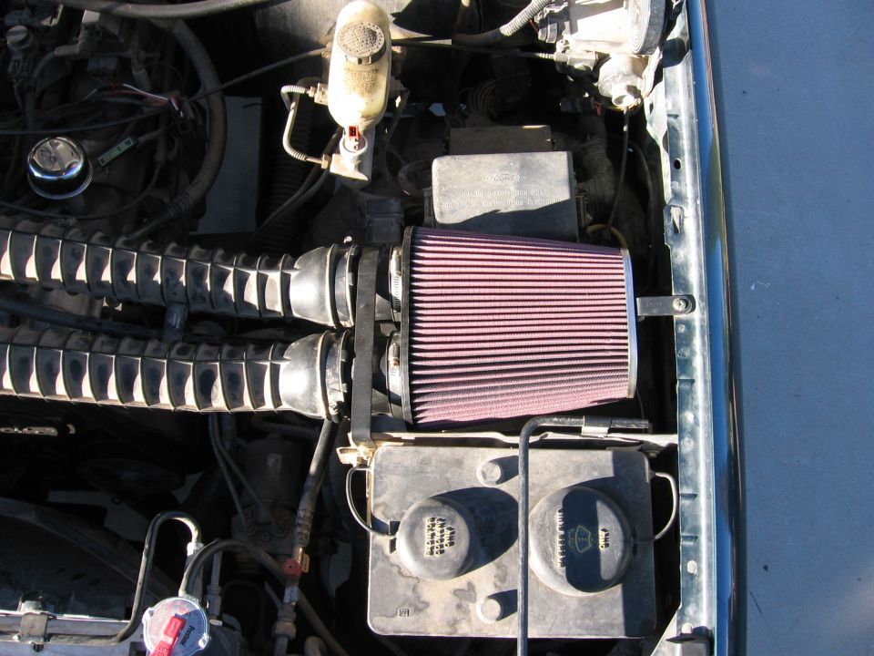 Engine bay with aftermarket cone air filter and dual ribbed intake hoses on a Ford Bronco