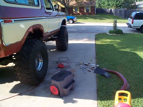 1979 Ford Bronco - Tools and a removed fender trim piece are laid out next to a lifted 1978 Ford Bronco.