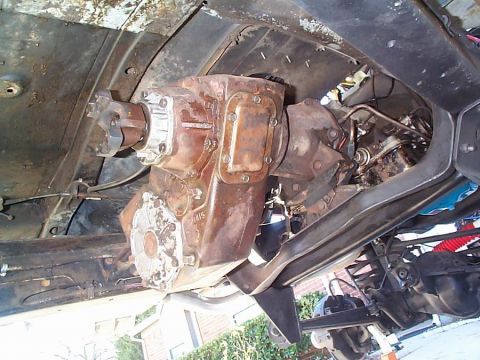 1979 Ford Bronco - Close-up of the vehicle's transfer case and associated drivetrain components, viewed from below.