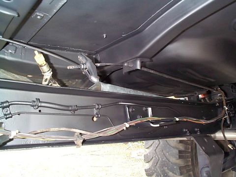 1979 Ford Bronco - Underside view of vehicle chassis with brake lines and electrical wiring clearly visible.