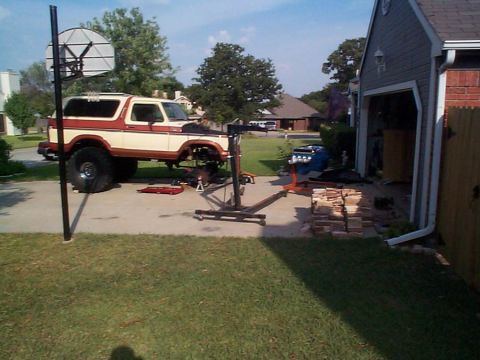 1979 Ford Bronco - Ford Bronco undergoing engine removal and repair in a residential driveway.