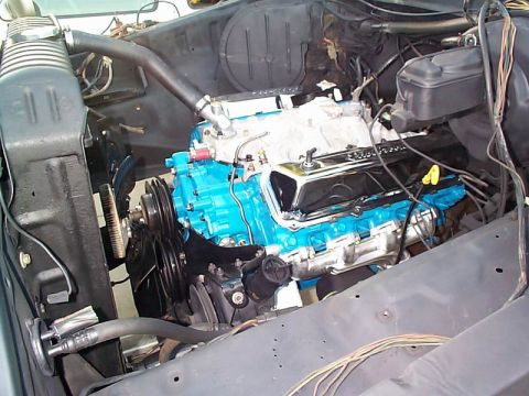1979 Ford Bronco - The engine bay shows a recently painted blue engine with chrome valve covers, ready for installation.