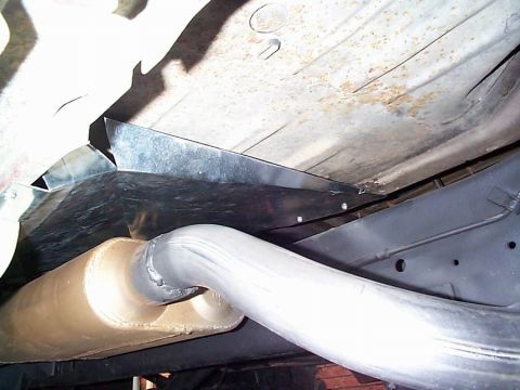1979 Ford Bronco - A view of the exhaust system and undercarriage components of a vehicle, with a watermark from Supermotors.net.