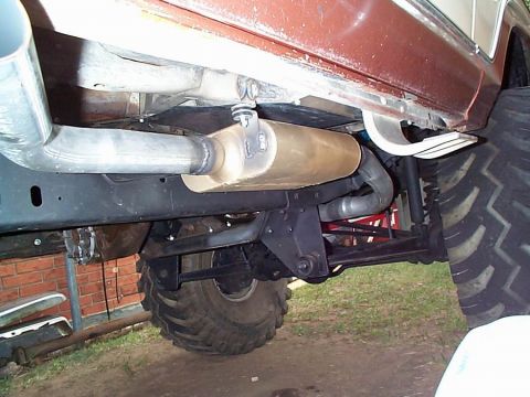 1979 Ford Bronco - Custom exhaust system and undercarriage components visible on a heavily modified vehicle with oversized tires.