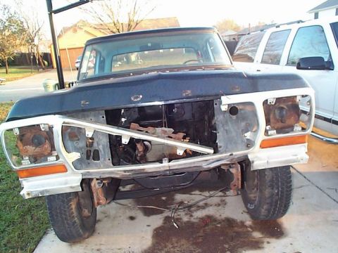 1979 Ford Bronco - The front of a disassembled 1979 Ford F-Series truck is shown, with its grille and headlights missing.