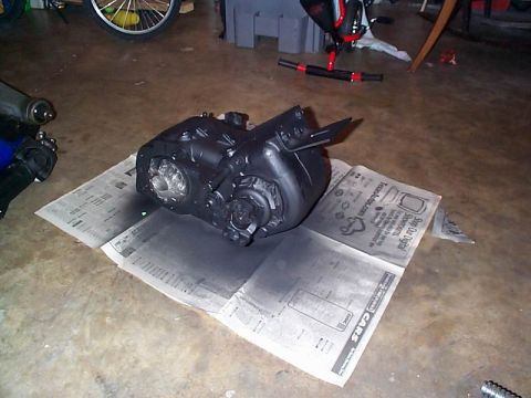 1979 Ford Bronco - A black transfer case sits on newspaper, likely being prepped for painting or cleaning.