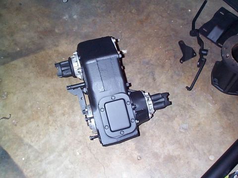 1979 Ford Bronco - A black NP205 transfer case is shown on a concrete surface with surrounding parts.