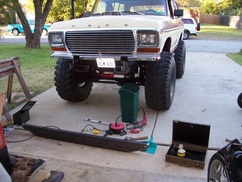 1979 Ford Bronco - A lifted 1978 Ford Bronco sits on a driveway with tools and a new bumper nearby.