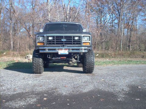 1986 Ford Bronco - Front view of a lifted 1986 Ford Bronco with large off-road tires.