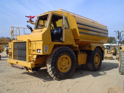 1966 International School Bus - This Caterpillar water truck features a large tank and a front-mounted fire nozzle, seen at a construction site.