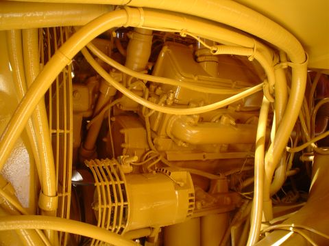 1966 International School Bus - Close-up view of a complex yellow engine bay, filled with numerous hoses and conduits.