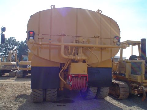 1966 International School Bus - This yellow water truck is equipped with a large tank and hose reel, seen with other construction vehicles.
