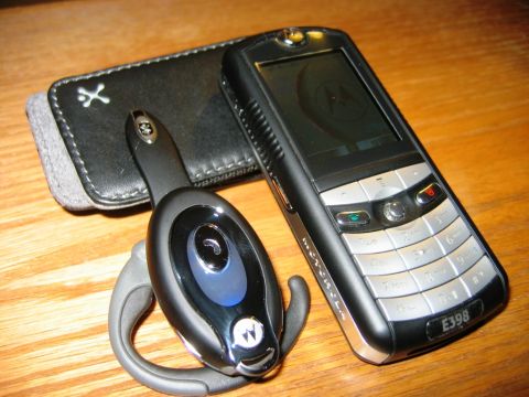 1985 Ford Bronco - A Motorola E398 phone and its accompanying Bluetooth headset are arranged on a wooden table.