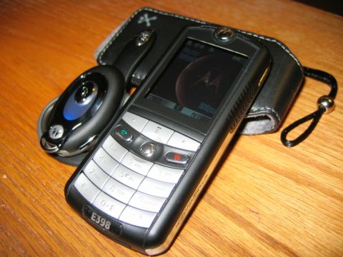 1985 Ford Bronco - Motorola E398 phone and accessories displayed on a wooden table.