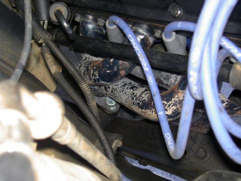 1988 Ford Bronco - Blue spark plug wires with 'Ford Racing' text are visible near the exhaust manifold in this engine bay detail.