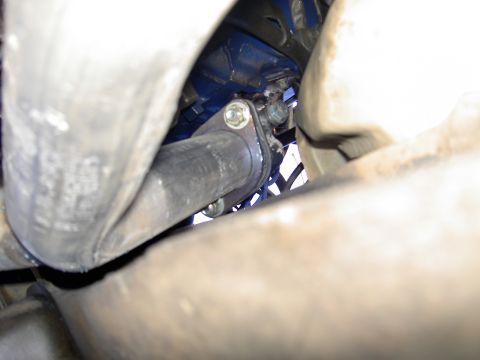 1988 Ford Bronco - This image shows a close-up view of a vehicle's exhaust system, specifically focusing on a pipe connection.