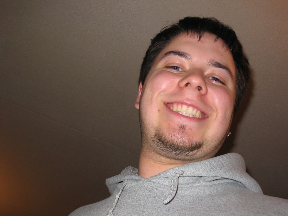 Man in grey hoodie smiling, with "SUPERMOTORS www.supermotors.net" logo on his hoodie