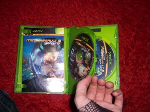 1997 Ford Probe - Open Xbox game case for MechAssault 2: Lone Wolf, showing the game disc and manual.