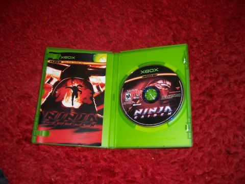 1997 Ford Probe - Xbox game case for Ninja Gaiden, showing the disc and cover art on a red carpet.