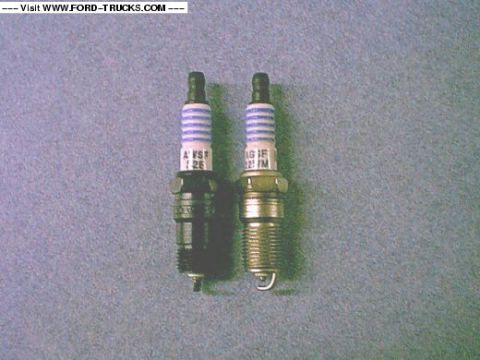 2005 Ford Excursion - Two spark plugs are shown side-by-side against a textured gray background.