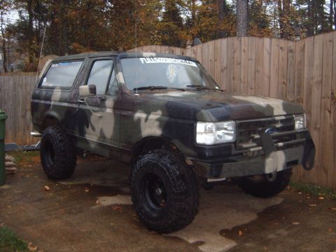 1988 Ford Bronco - This lifted Ford Bronco is painted in a camouflage pattern and sits on large off-road tires.
