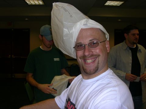 1997 Ford Probe - A man wears a plastic bag over his head while two other men stand behind him.