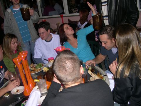 1997 Ford Probe - People socialize around a table filled with drinks and food, with one woman raising a large mug.