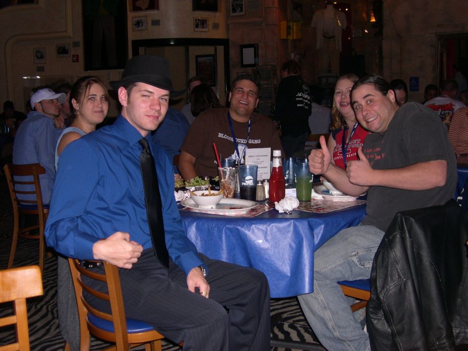 People sitting at a blue-covered table in a restaurant, with food and drinks