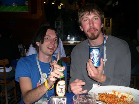 1997 Ford Probe - Two men are pictured holding drinks at a table, with one man pointing with a beer bottle and the other holding a can.