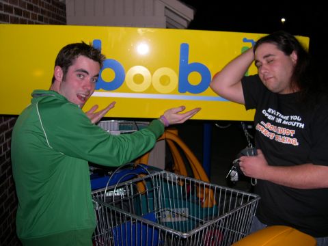1997 Ford Probe - Two men pose in front of a sign with a shopping cart in the foreground.