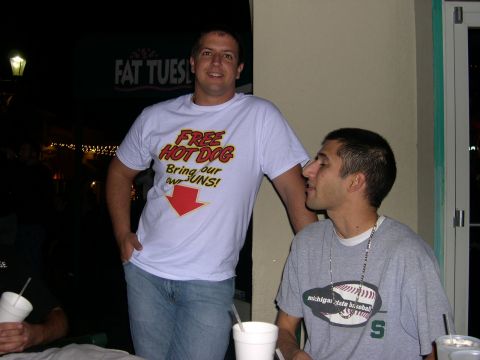1997 Ford Probe - Two men are seen at an outdoor venue, one wearing a shirt that says "Free Hot Dog" and the other looking away.