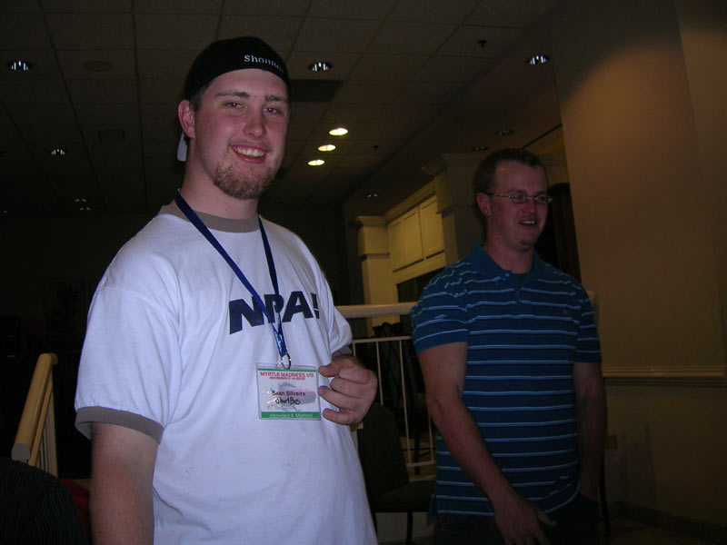 Man in white t-shirt with 'NPA!' logo and lanyard with ID badge