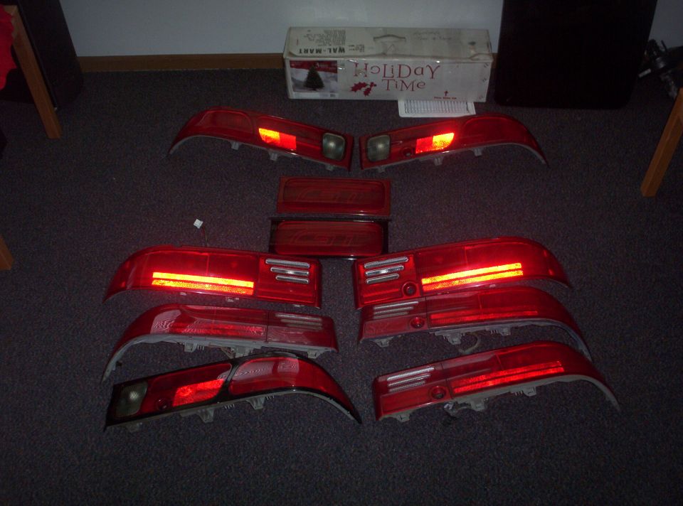 Several red car tail lights laid out on a carpeted floor