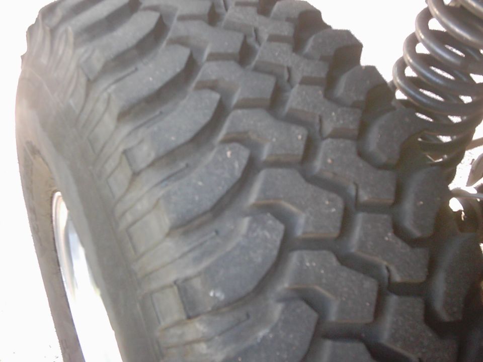 Close-up of a knobby off-road tire and a black coil spring
