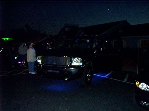 2000 Ford Excursion - A black pickup truck is parked at night with blue lights illuminating the ground beneath it.