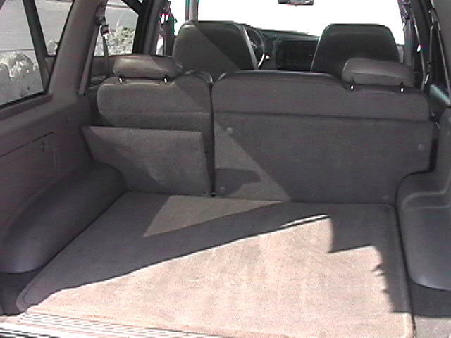 Gray interior of a 1998 Ford Explorer with folded rear seats and a cargo area