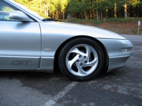 1994 Ford Probe - The front quarter panel and wheel of a silver 1994 Ford Probe GT are visible in this image.