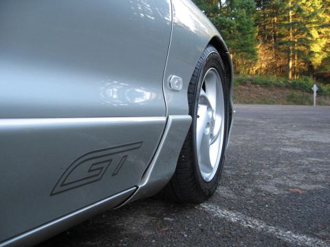 1994 Ford Probe - Close-up of a silver car's side panel, showing the GT emblem and wheel.